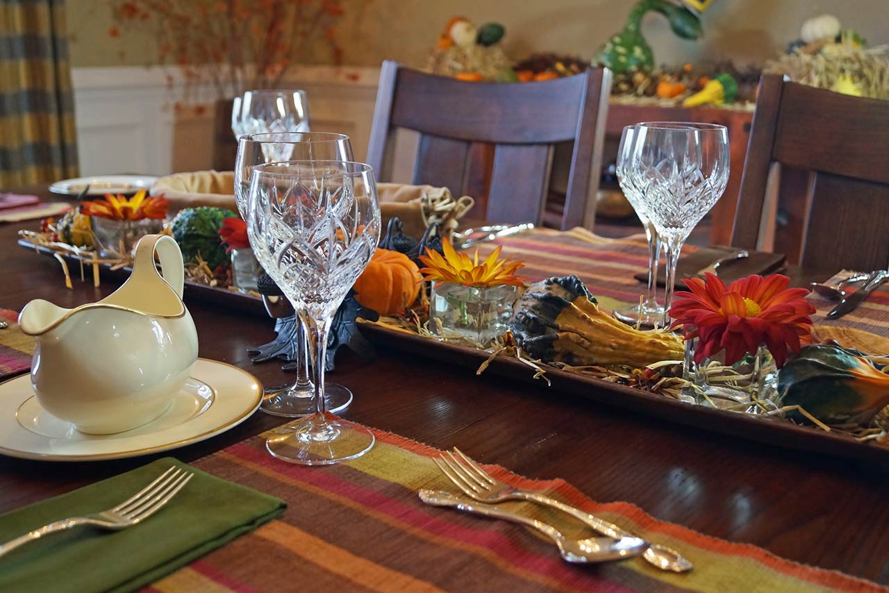 Photo of a formal dining room table elegantly decorated for Thanksgiving or a harvest themed Fall dinner party.
