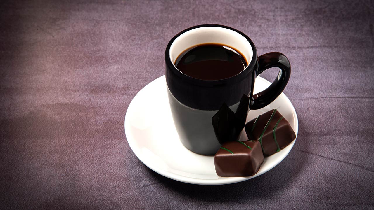 Photo of a cup of espresso with chocolate bonbons.