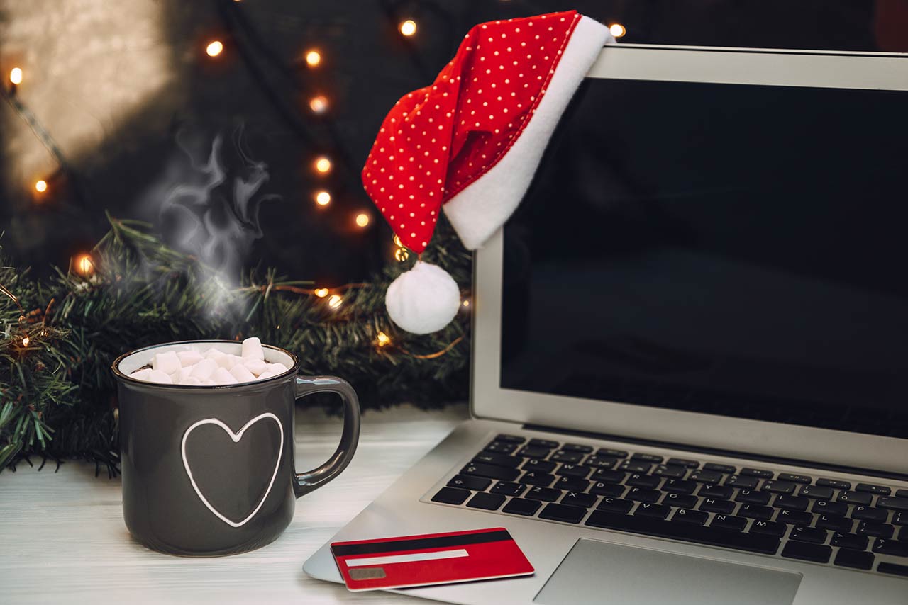 Photo of a laptop, cup of hot cocoa and credit card