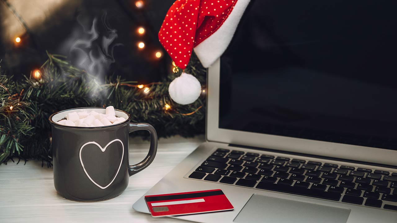 Photo of a laptop, cup of hot cocoa and credit card