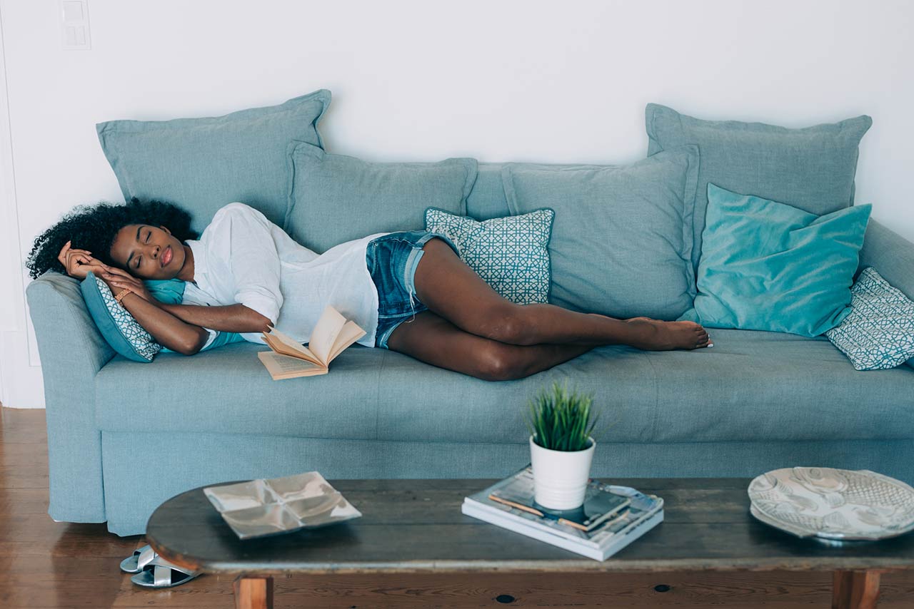Photo of a beautiful black young woman sleeping on the sofa