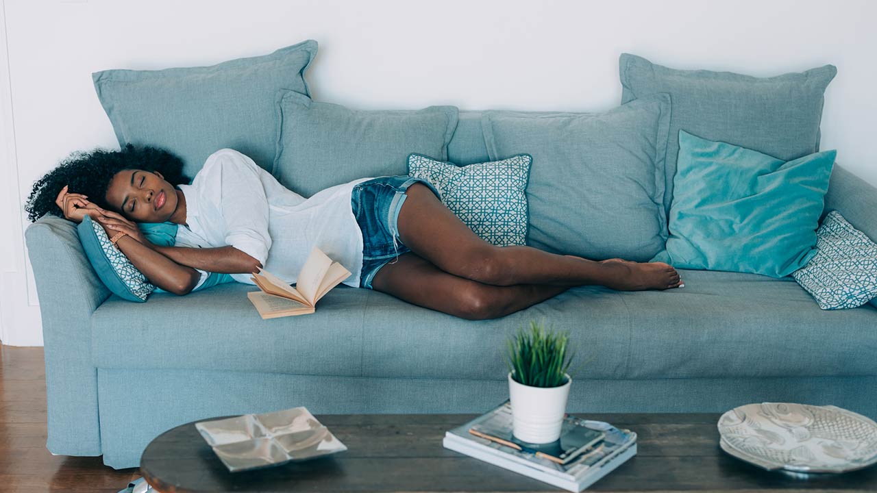 Photo of a beautiful black young woman sleeping on the sofa