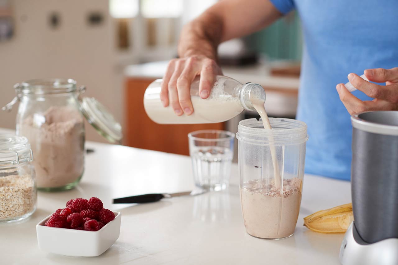 Close Up Of Man Making Protein Shake After Exercise At Home