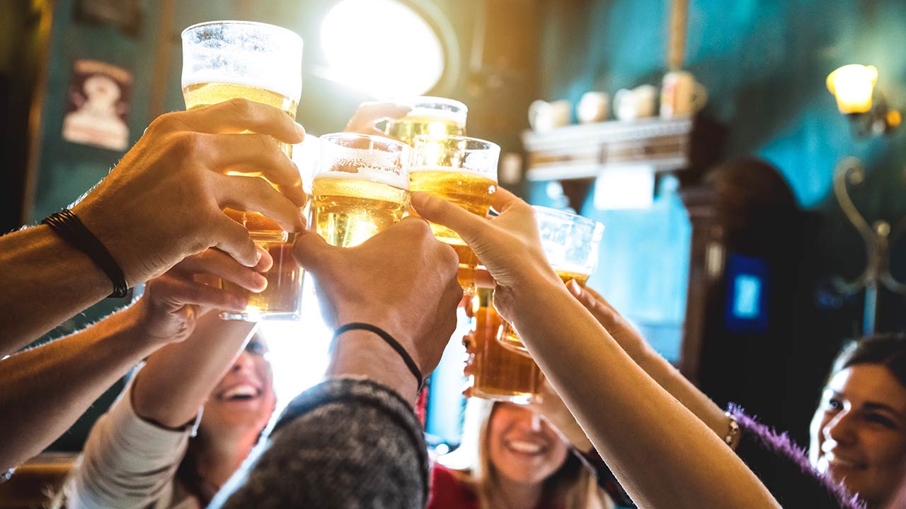 Group of happy friends drinking and toasting beer at brewery bar restaurant