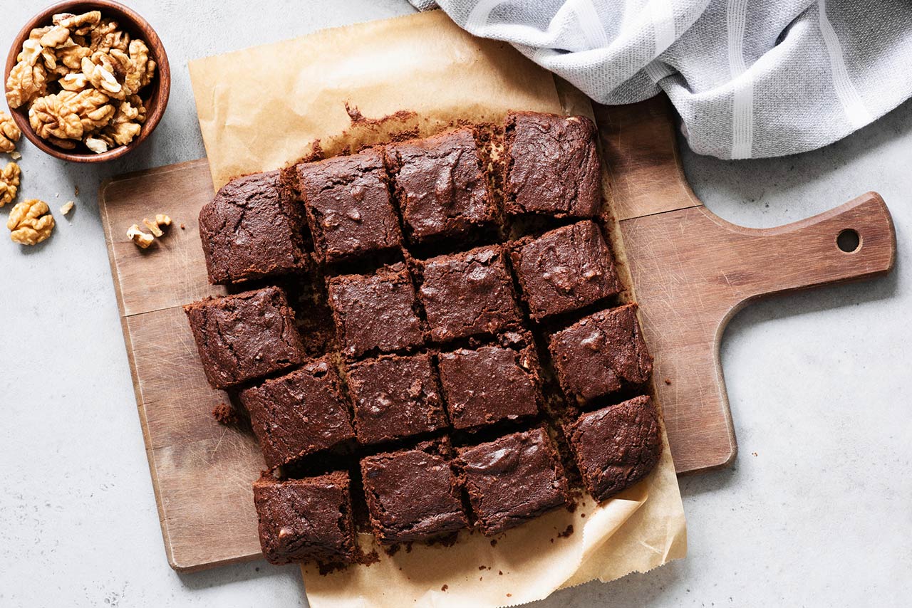 Chocolate brownie squares with walnuts on cutting board