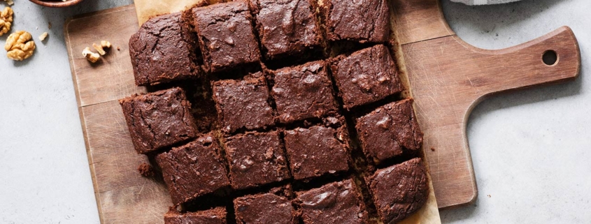 Chocolate brownie squares with walnuts on cutting board