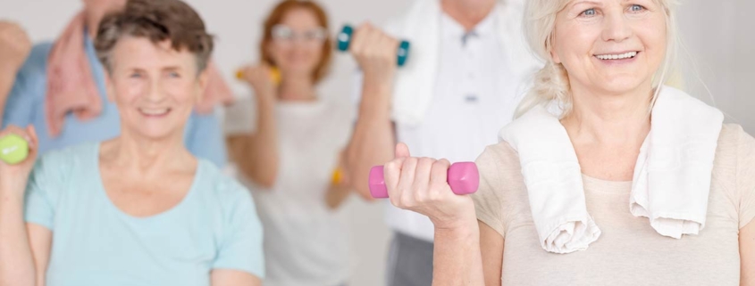 Elder happy people working out with colorful dumbbells
