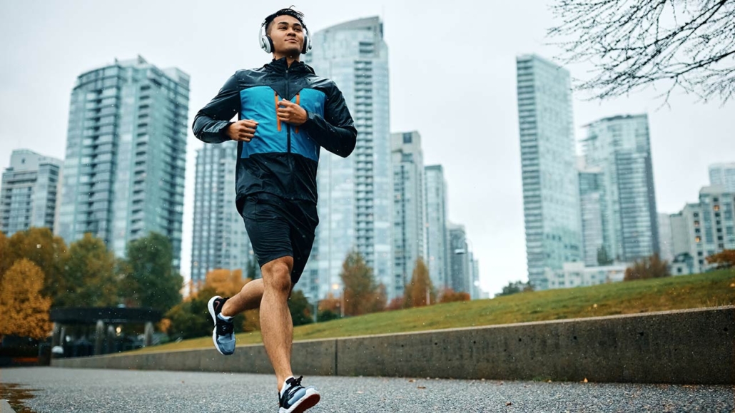 Low angle view of motivated athletic man running during rainy day