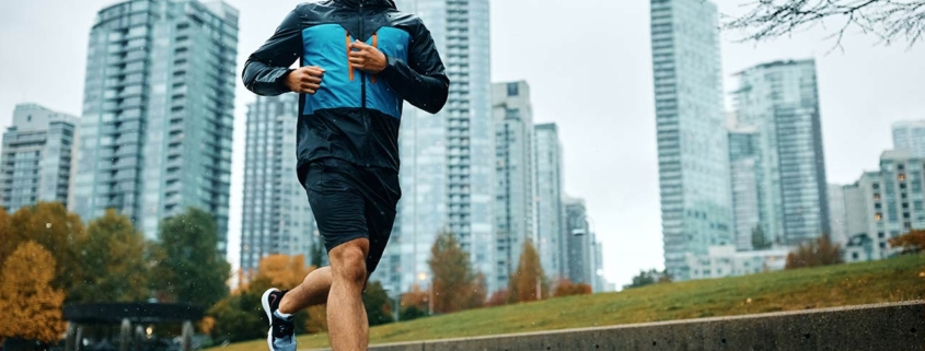Low angle view of motivated athletic man running during rainy day