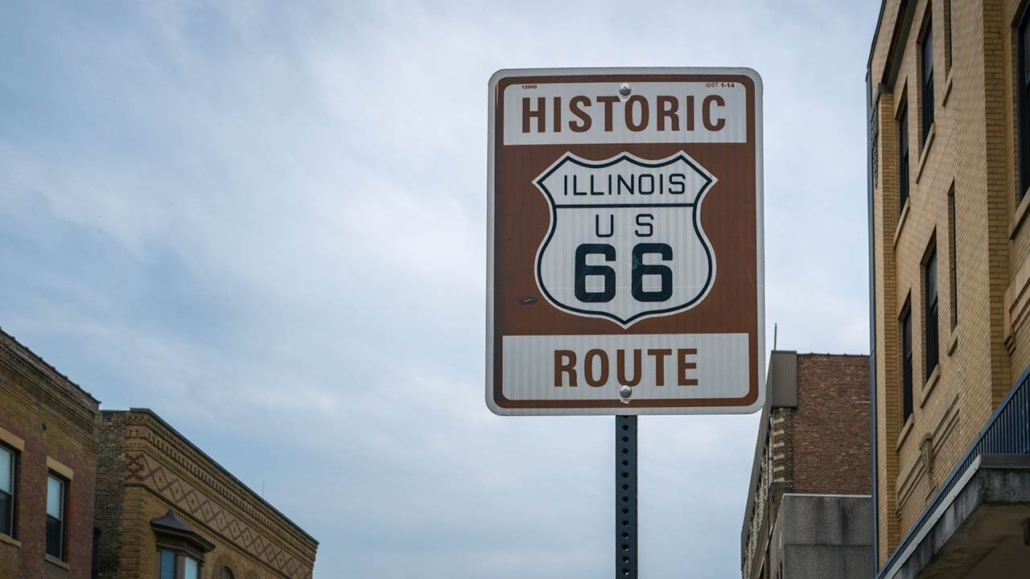 Historic Illinois US 66 Route sign and old brick buildings in Bloomington City, Illinois