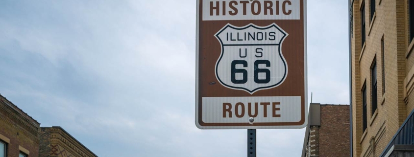 Historic Illinois US 66 Route sign and old brick buildings in Bloomington City, Illinois