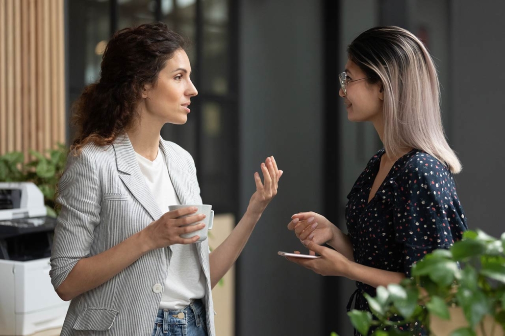 Diverse employees chatting during coffee break at office