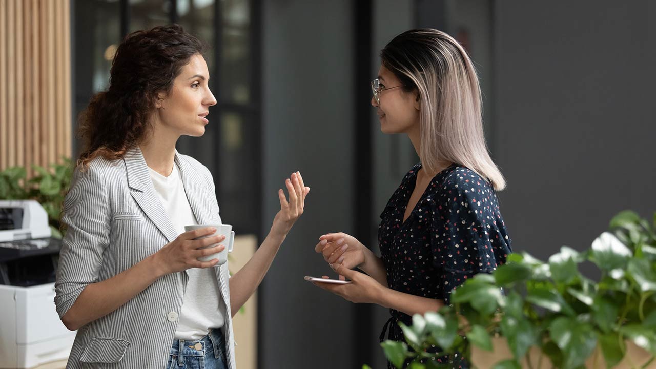 Diverse employees chatting during coffee break at office