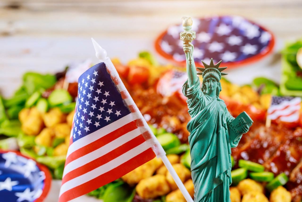 Statue of Liberty and American flag on party table with blurry food not in focus