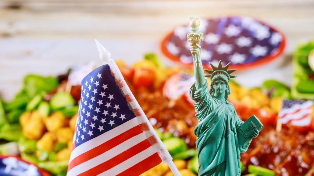 Statue of Liberty and American flag on party table with blurry food not in focus