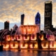 Water fountain with beautiful sunset and colorful light changes illuminating the Chicago skyline in the background