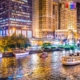 Beautiful downtown Chicago at night with lit buildings, river and bridge