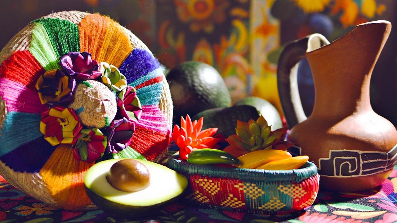 traditional mexican woven basket, chili peppers, avocado and traditional rustic clay jug