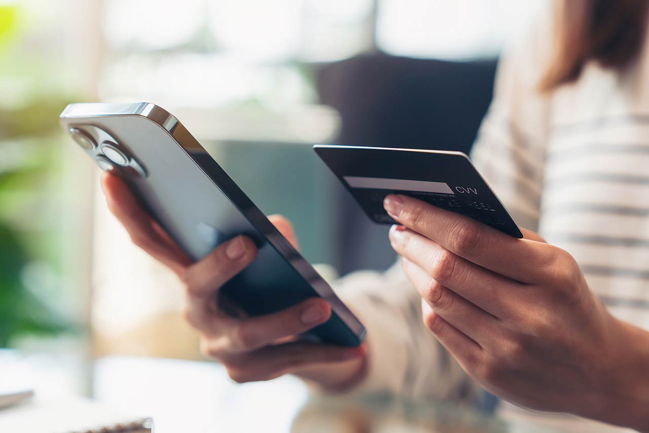 Woman hand holding credit cards and using smartphone for shopping online with payment on internet banking