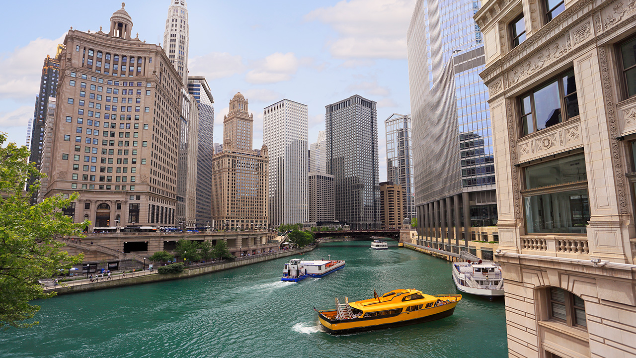 Chicago River with water taxi and boats sailing between the beautiful skyscrapers skyline
