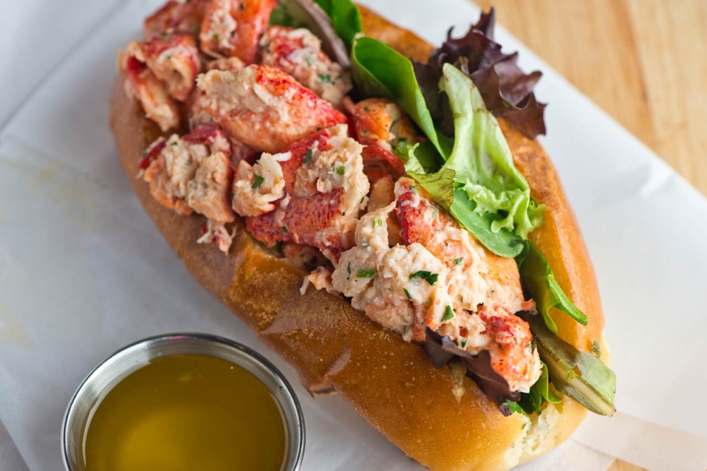Lobster roll on toasted hotdog bun w/ lettuce, tomato, garlic mayo seasoned salt & pepper