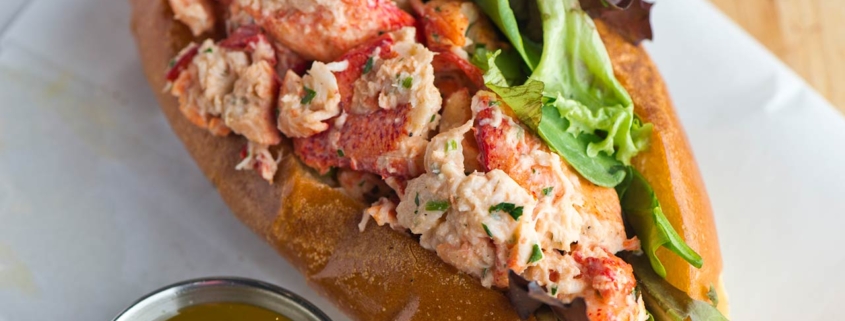 Lobster roll on toasted hotdog bun w/ lettuce, tomato, garlic mayo seasoned salt & pepper