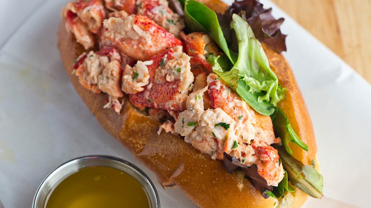 Lobster roll on toasted hotdog bun w/ lettuce, tomato, garlic mayo seasoned salt & pepper