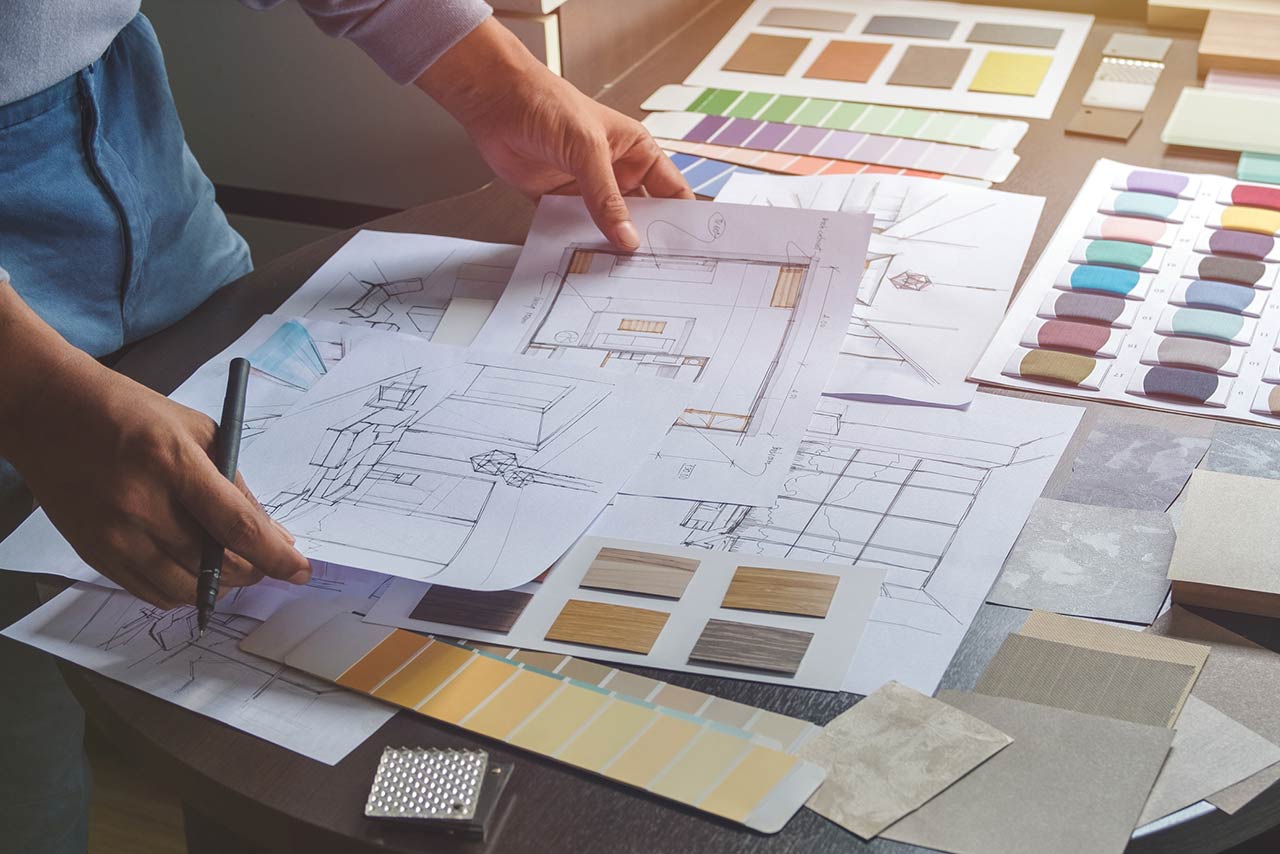 Interior designer working on hand drawing sketches on plan blueprints