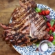 Ovehead view on serving of Italian Florentine steak with garnish on rustic wooden table