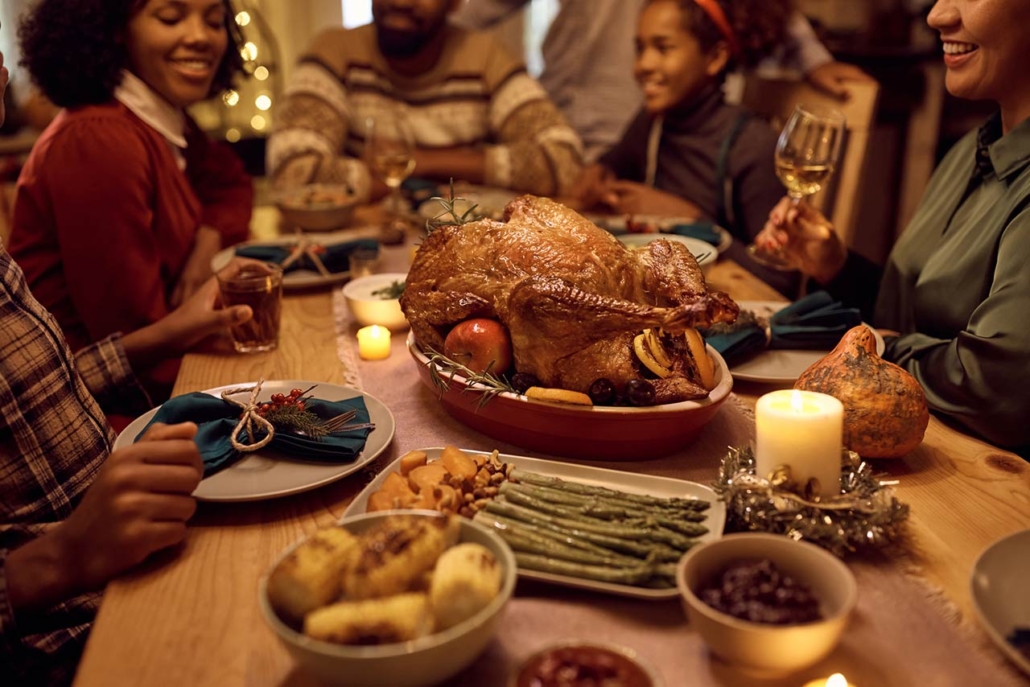 Close up of African American family gathering for Thanksgiving dinner at dining table