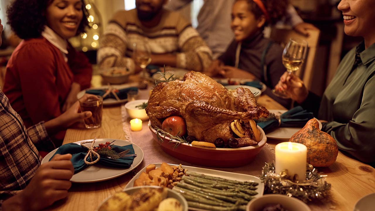 Close up of African American family gathering for Thanksgiving dinner at dining table