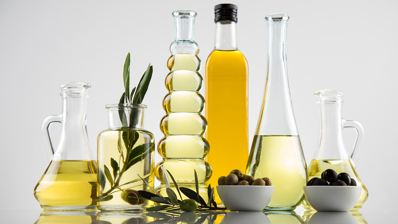Bottles with organic cooking olive oil and olive branch