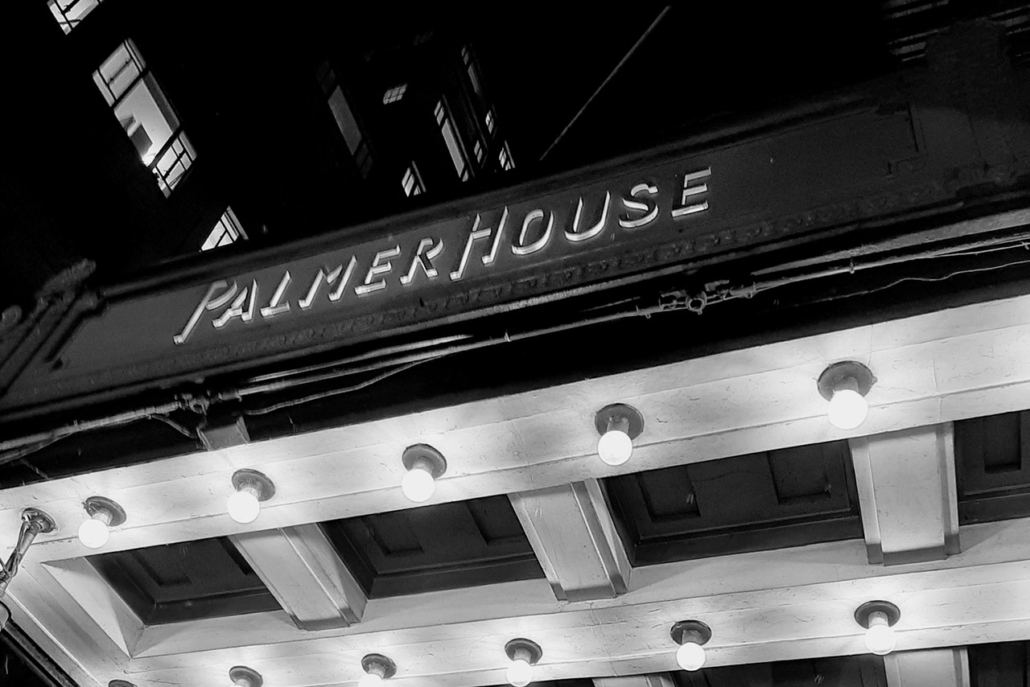 In black and white, a low angle view of the Palmer House name in Chicago