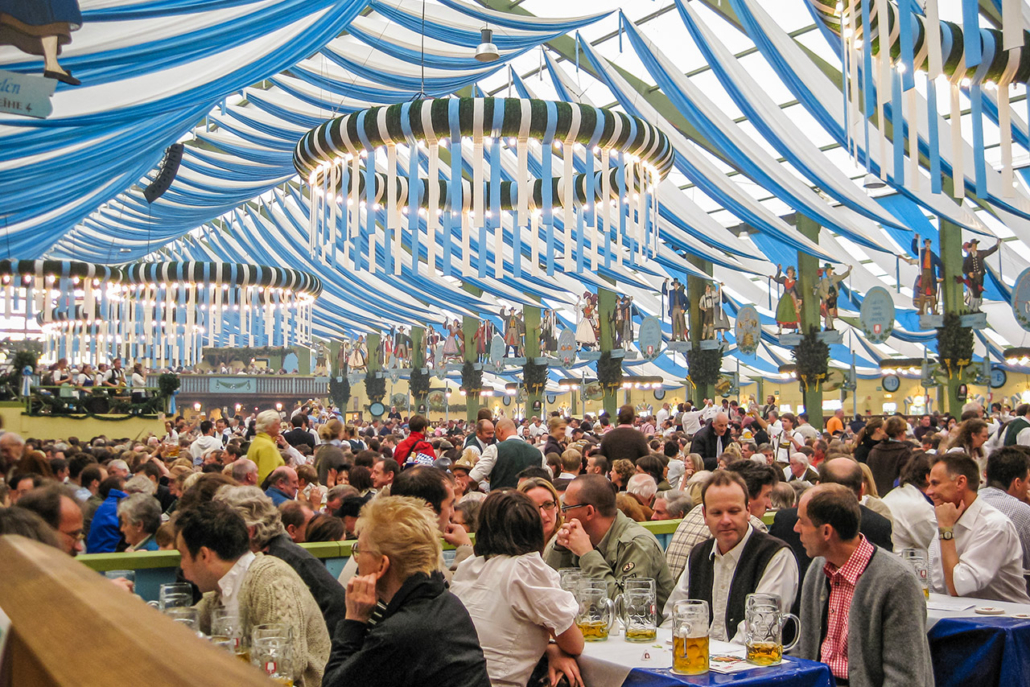 A festive crowd enjoys the traditional brass band in the packed spatenbrau Ochsenbraterei tent at Munich Oktoberfest