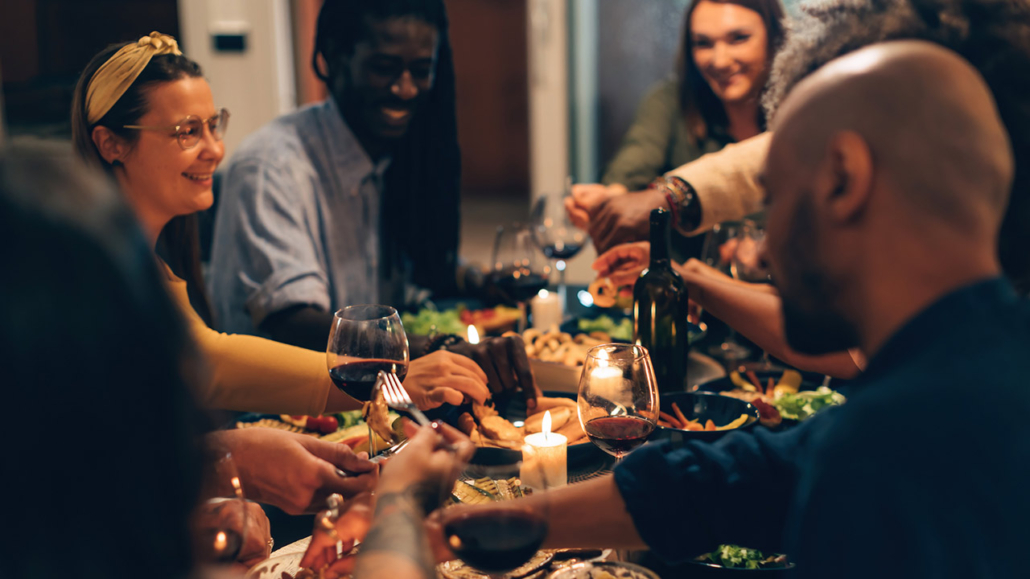 multiethnic people sitting together in a joyful night eating vegetarian food