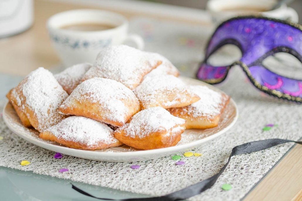 Homemade New Orleans style beignets are small squares of fried dough covered in powdered sugar prepared for Mardi gras