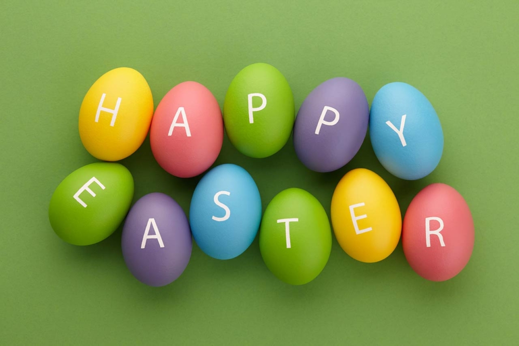 colorful painted eggs with happy easter letters on green background