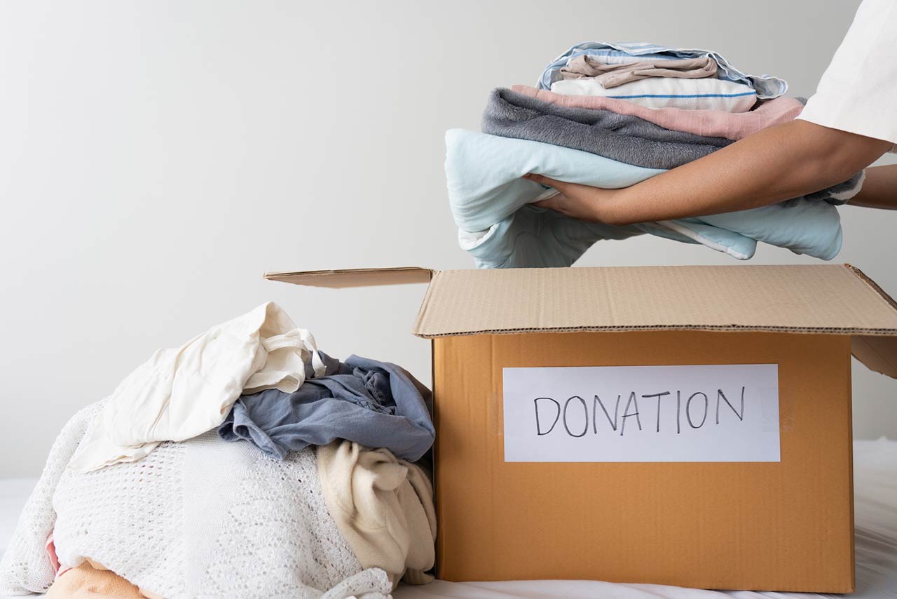 woman hands holding clothes putting in a donation box