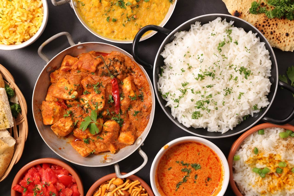 assortment of indian food in bowls and pans