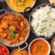 assortment of indian food in bowls and pans