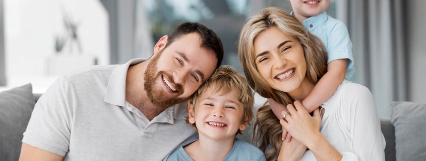 Portrait of smiling caucasian family relaxing together on a sofa at home