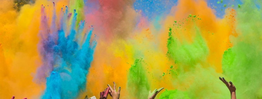 crowd of people throwing colored paint on Holi festival