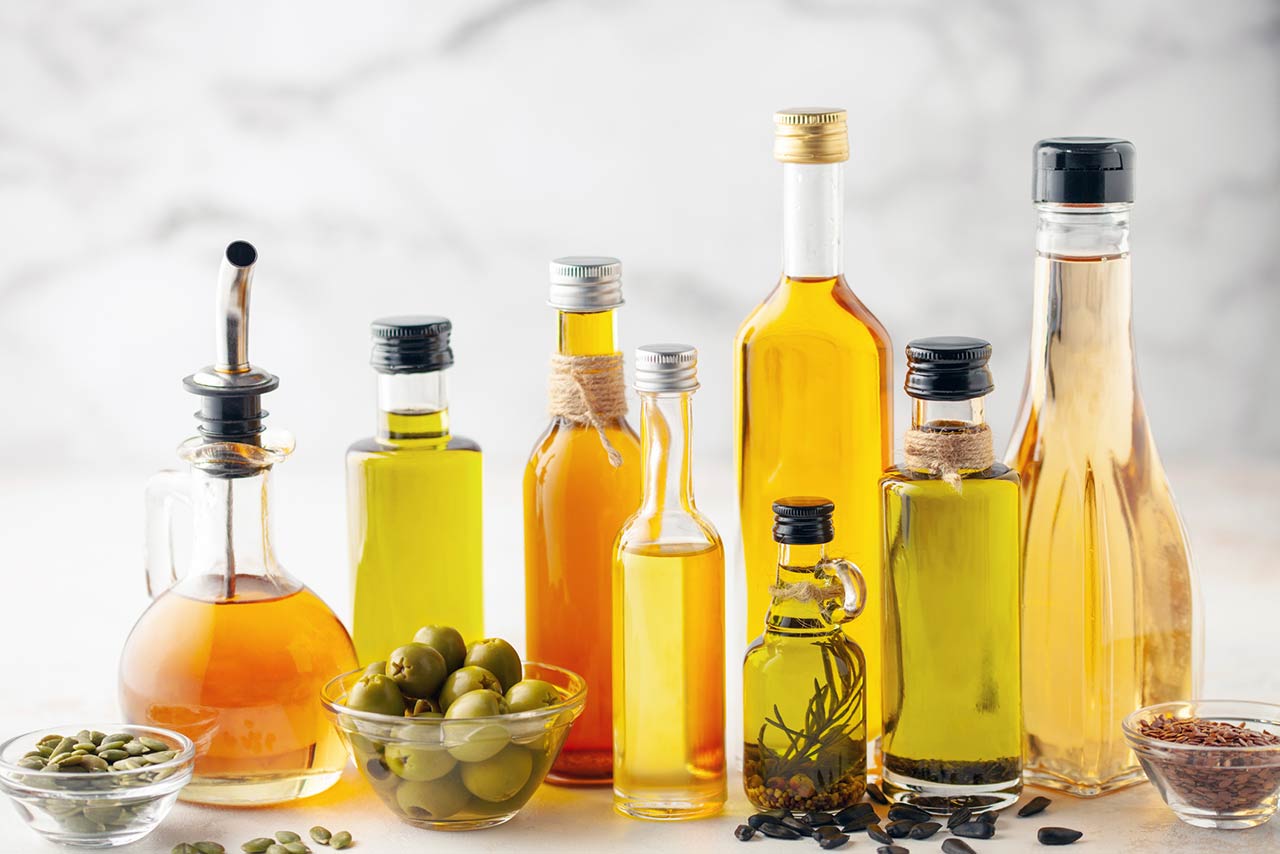 Various vegetable and seed oil in bottles on a bright background