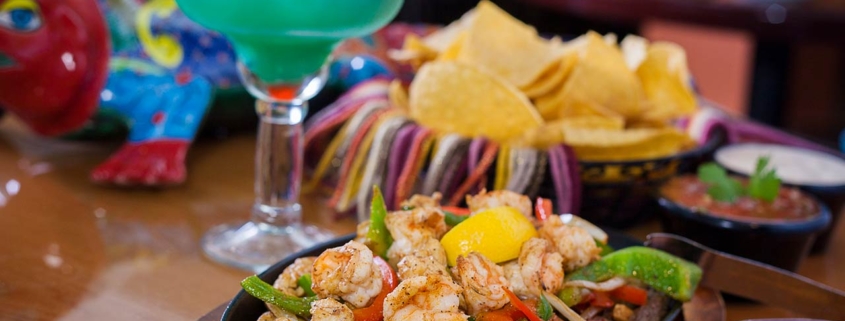 Steak and shrimp fajitas with a blue margarita, such and chips