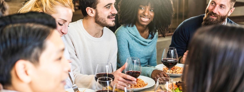 Diverse group of millennials sharing a meal and smiles