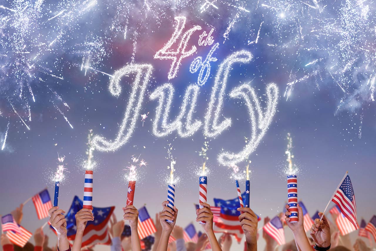 Hands holding firecrackers with 4th of July smoke lettering