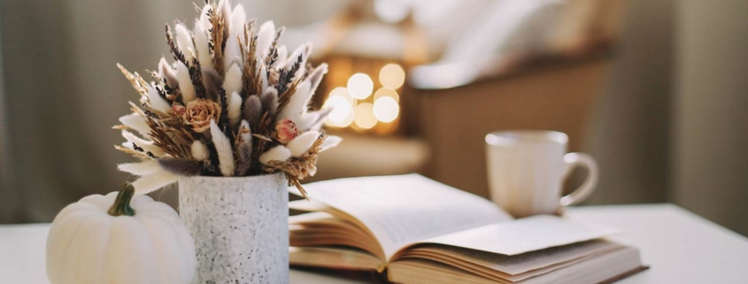 Fall home decoration stock photo with dried flowers, book, and a teacup