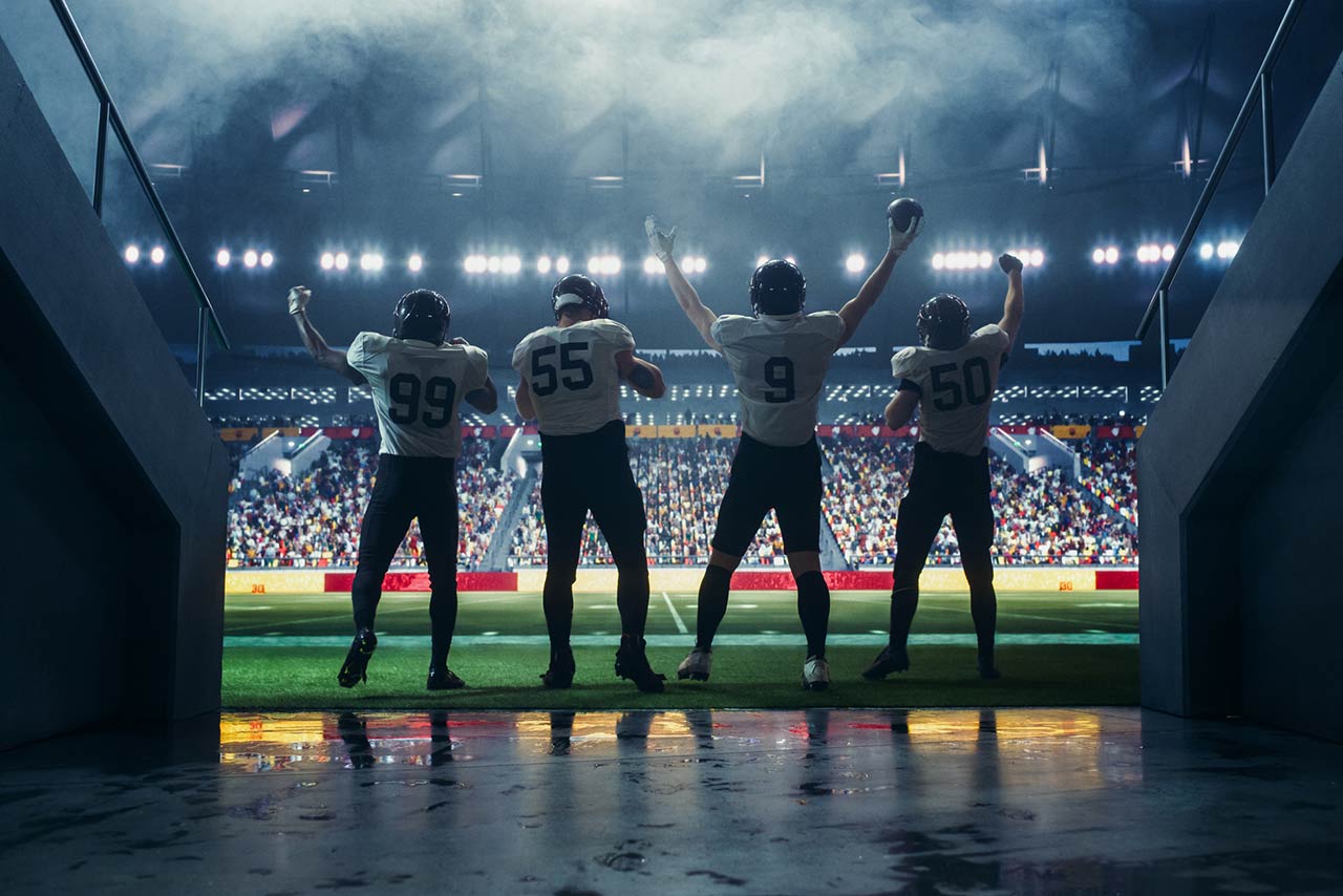 Diverse American Football Players Walking Out of a Stadium Tunnel