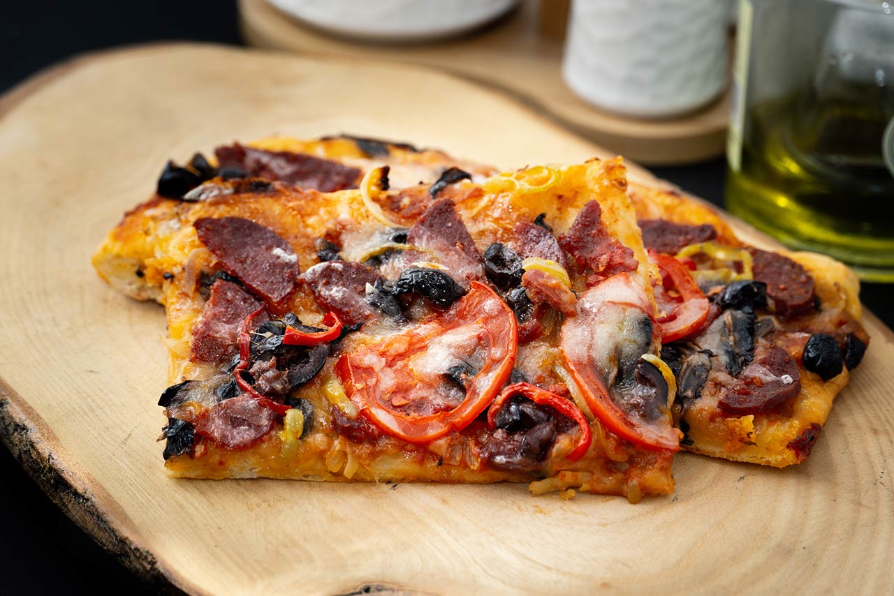 homemade sliced pizza on wooden cutting board