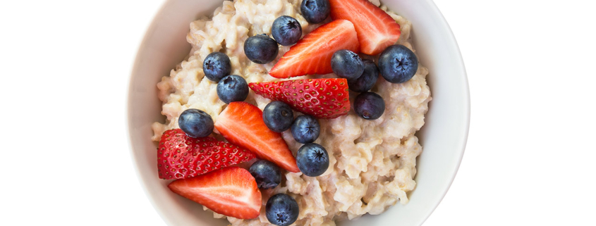 Homemade oatmeal with blueberries and strawberries in bowl isolated on white background stock photo